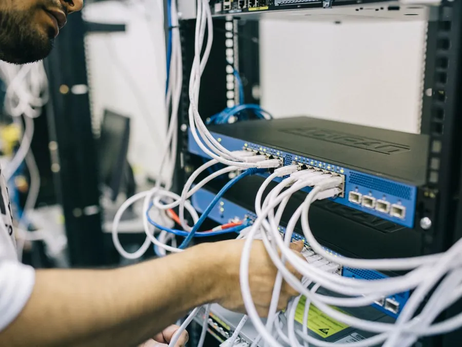 Technician patching network cables in a data cabinet